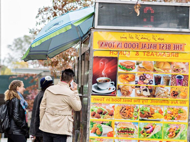 Halal food truck with colorful food posters and people in line